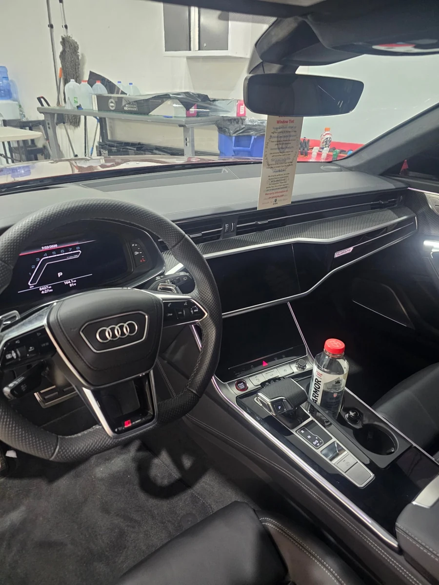 A freshly cleaned Audi interior with a spotless steering wheel, dashboard and center console inside the shop