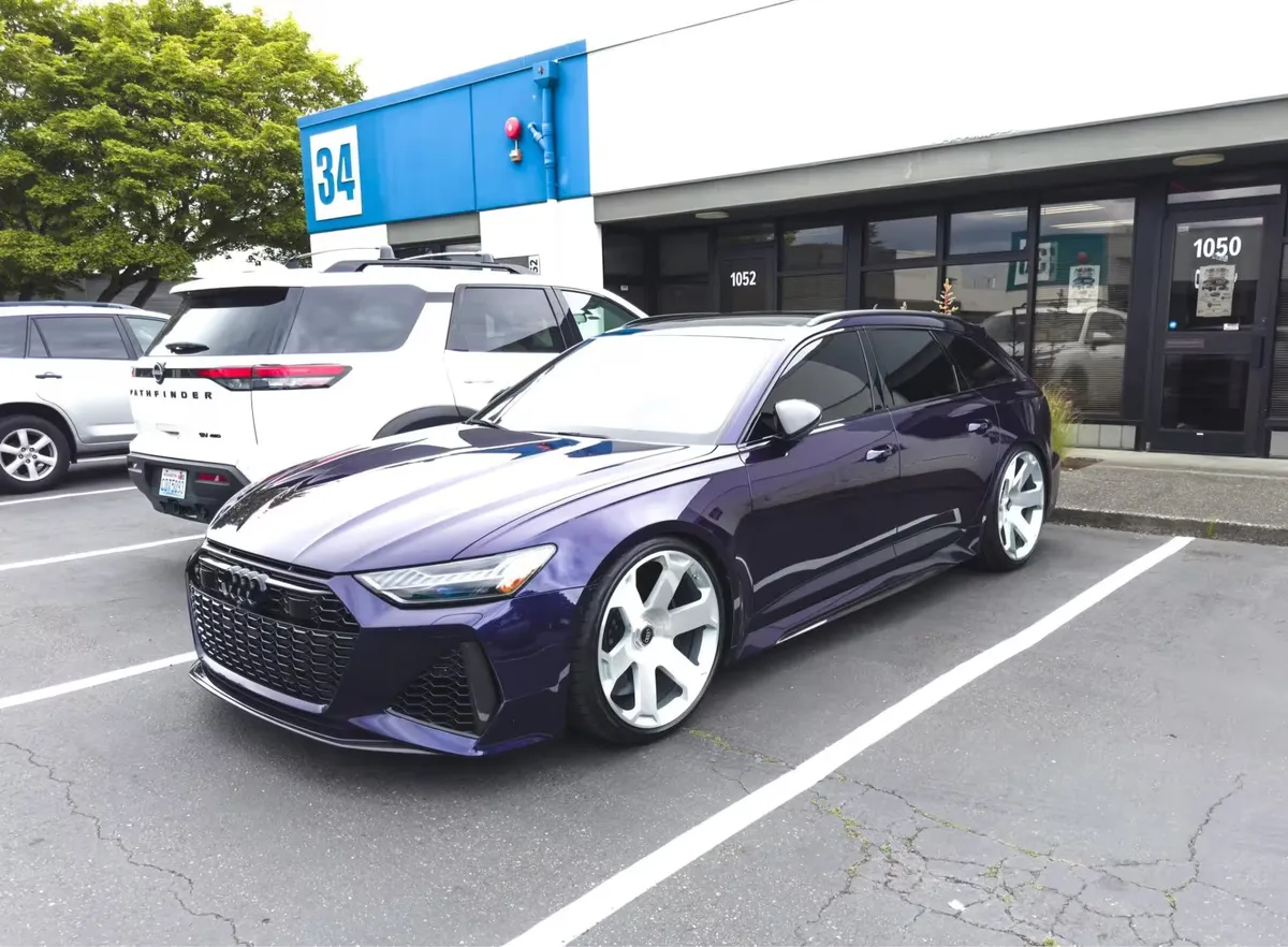 A dark purple Audi wagon parked outside the APC Auto Spa Tukwila shop at 1050 Industry Drive